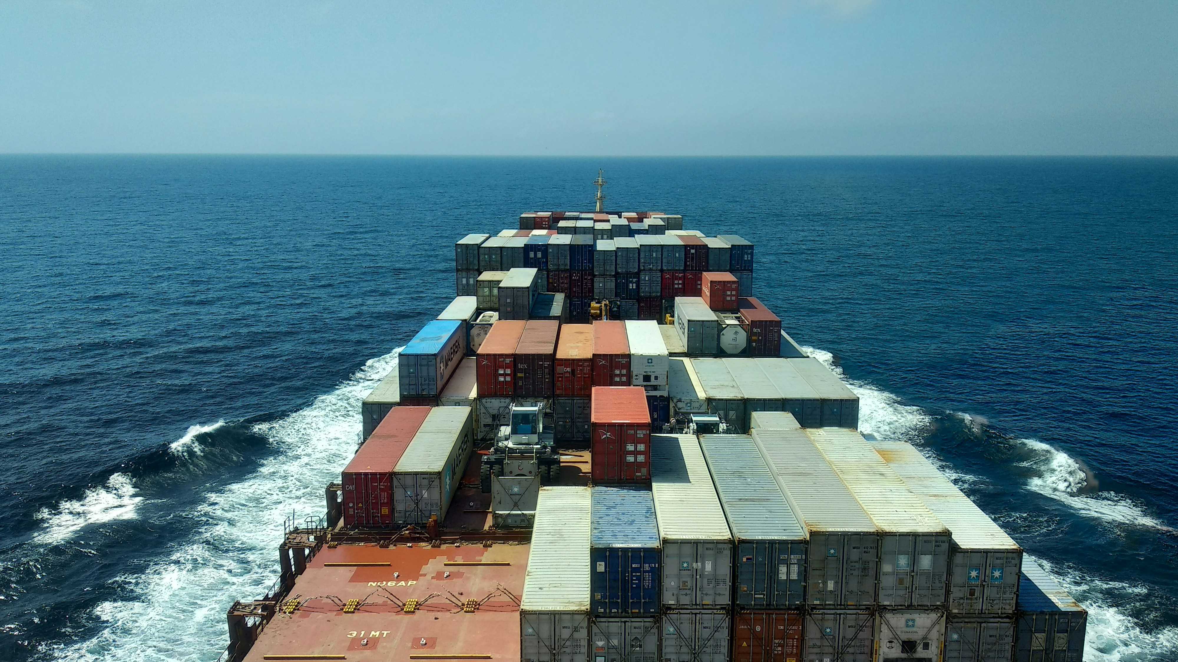 Container ship deck at sea, illustrating the point where Incoterms risk typically transfers between buyer and seller