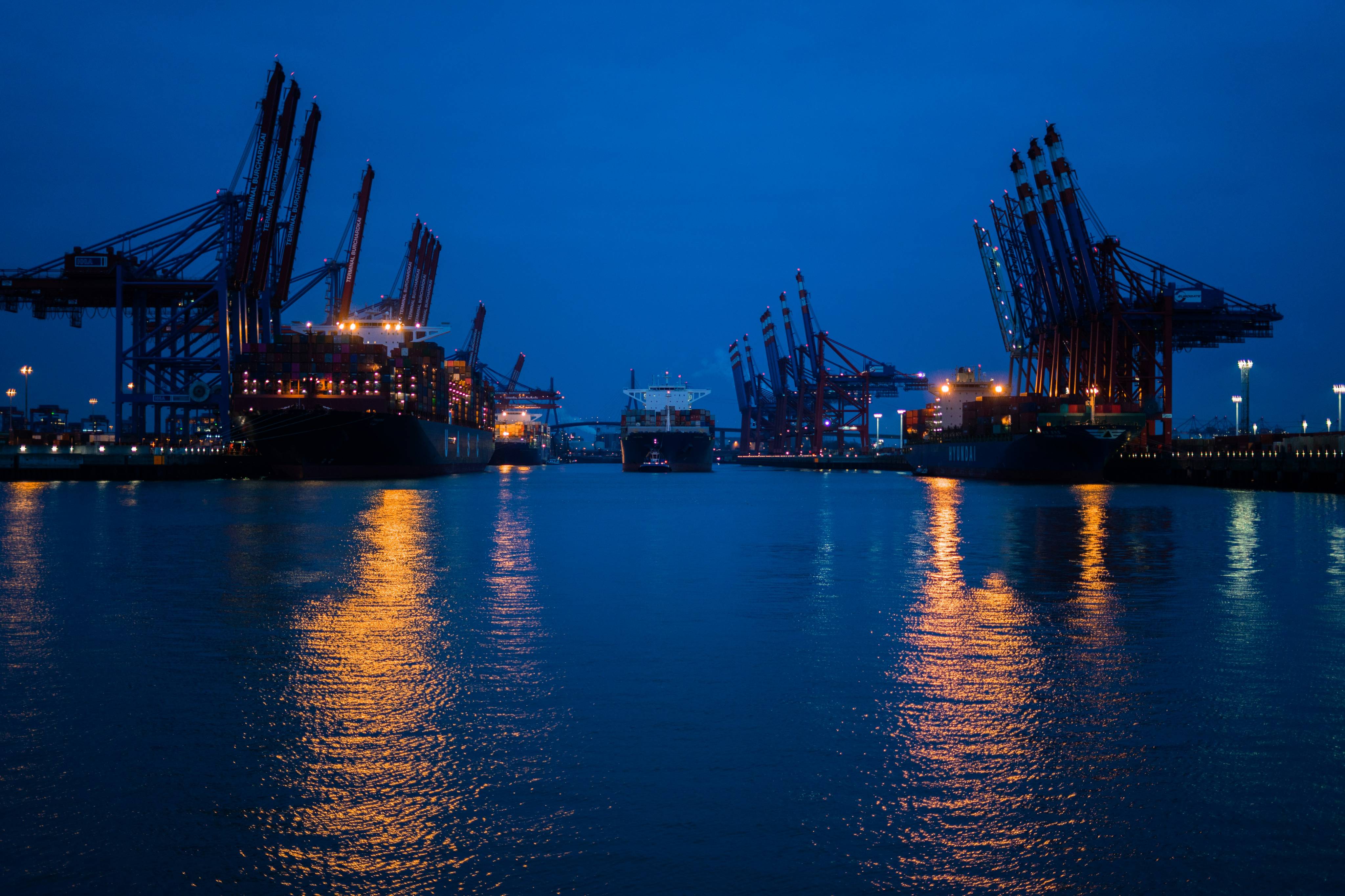 Container terminal at twilight with harbor reflections
