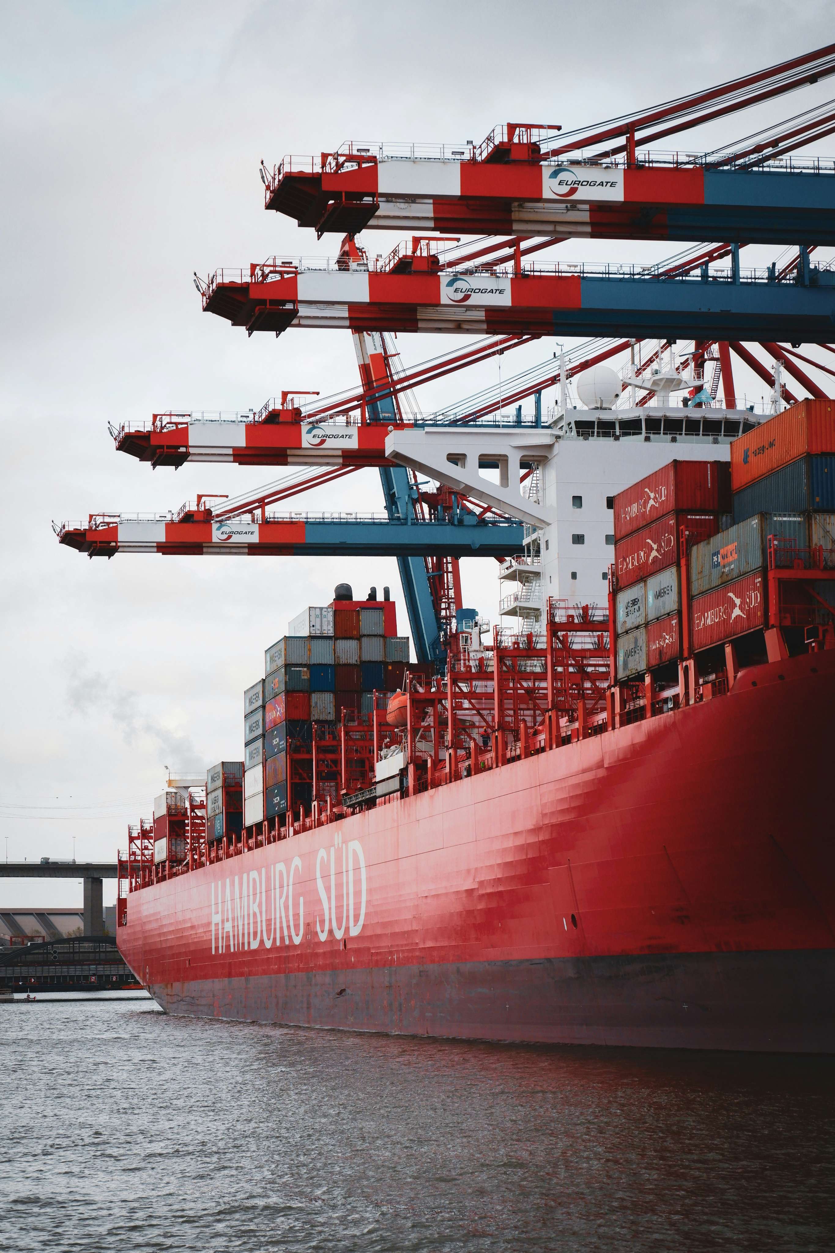 Container ship at a port terminal loaded with standard and specialised shipping equipment